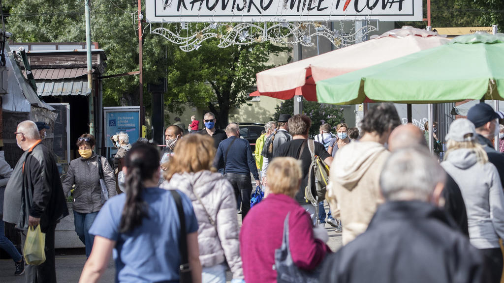 02.05.2020, Slowakei, Bratislava: Menschen mit Mundschutz gehen auf einem Marktplatz an den Ständen vorbei. Foto: Martin Baumann/TASR/dpa +++ dpa-Bildfunk +++