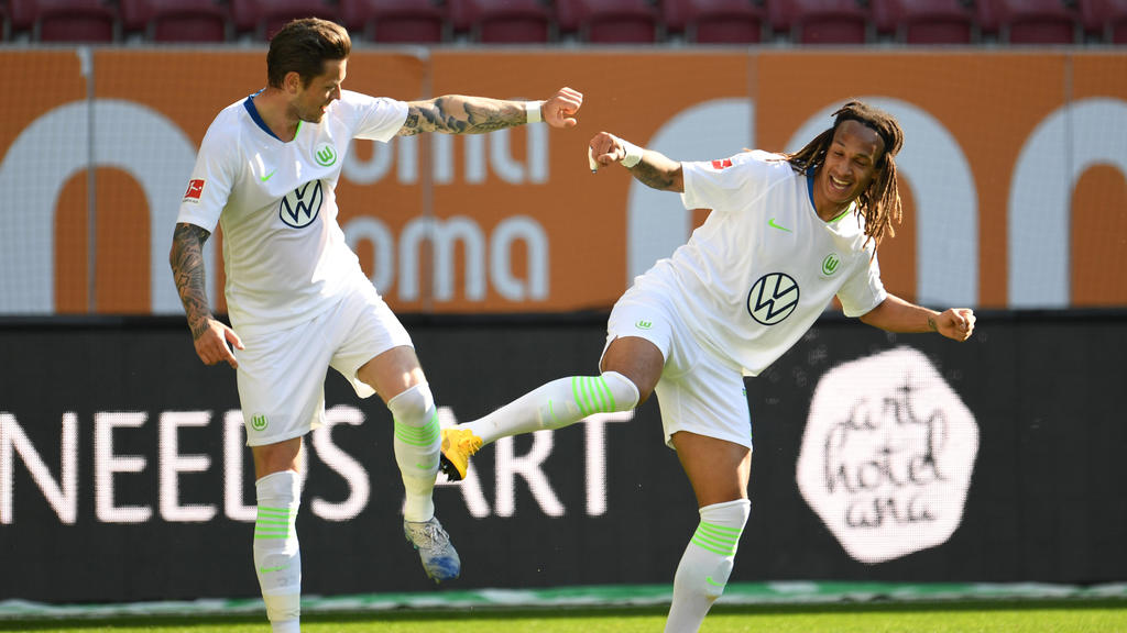 16.05.2020, Bayern, Augsburg: Fußball: Bundesliga, FC Augsburg - VfL Wolfsburg, 26. Spieltag in der WWK-Arena in Augsburg. Wolfsburgs Daniel Ginczek (l) bejubelt sein Tor zum 1:2 mit Wolfsburgs Kevin Mbabu. WICHTIGER HINWEIS: Gemäß den Vorgaben der D