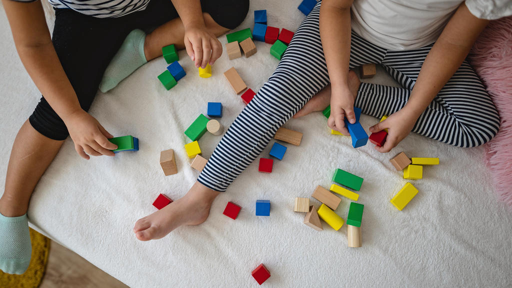 Kinder spielen mit Holz-Bauklötzen