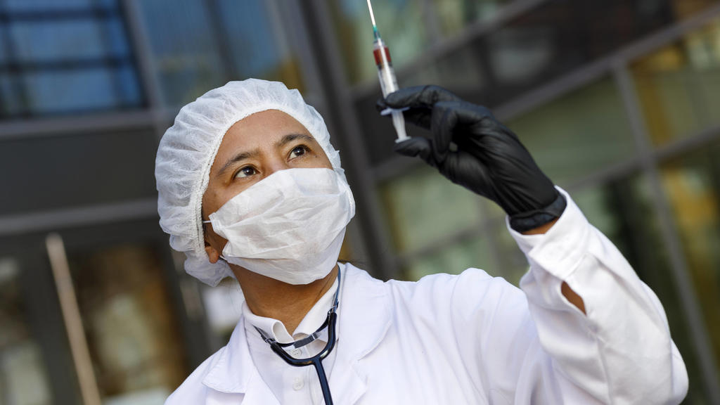 Eine Virologin posiert mit einer Spritze zur Impfung gegen das Corona-Virus. Symbolfoto mit Model Nürnberg, 23.04.2020 *** A virologist poses with a syringe for vaccination against the corona virus Symbol photo with model Nuremberg, 23 04 2020 Foto: