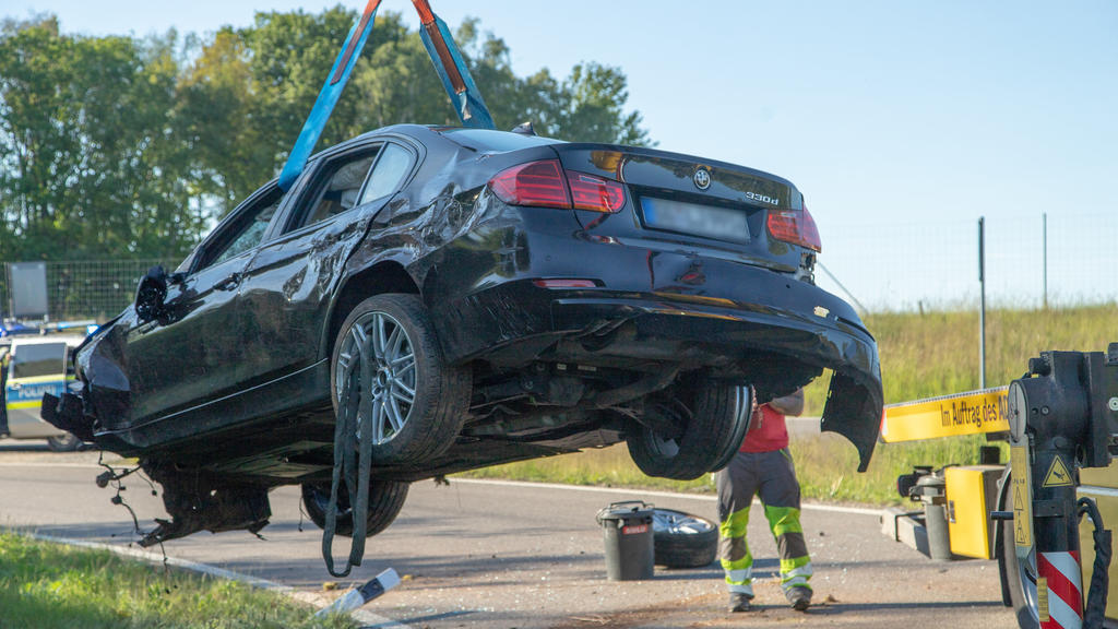 21.05.2020, Sachsen, Hartenstein: Ein BMW wird nach einem schweren Unfall an der Autobahnausfahrt Hartenstein der A72 von einem Abschleppfahrzeug geborgen. Bei dem Unfall war der Mannschaftsbus des Fußball-Zweitligisten FC Erzgebirge Aue von Trümmert