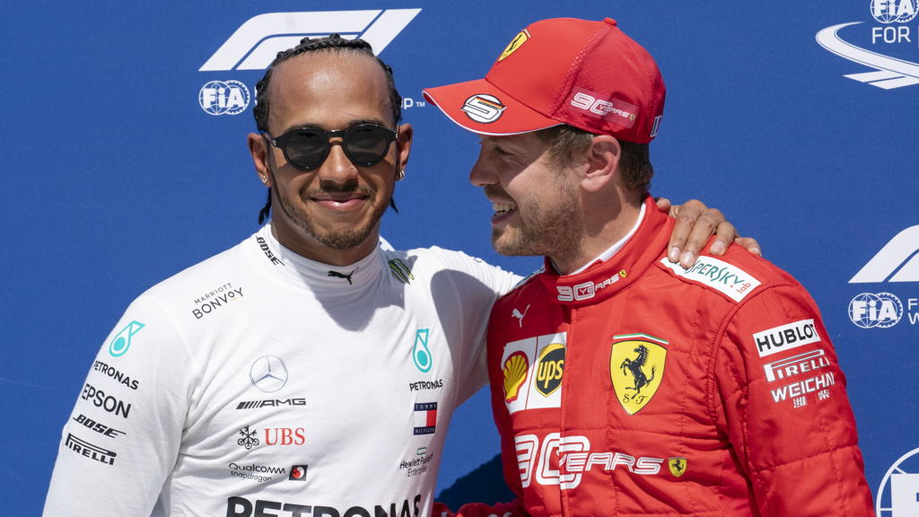 ARCHIV - 08.06.2019, Kanada, Montreal: Motorsport: Formel-1-Weltmeisterschaft, Grand Prix von Kanada, Qualifying: Lewis Hamilton (l) aus Großbritannien vom Team Mercedes gratuliert Sebastian Vettel aus Deutschland vom Team Scuderia Ferrari zur Pole-P