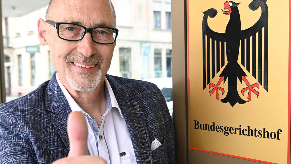 25.05.2020, Baden-Württemberg, Karlsruhe: Herbert Gilbert, Kläger gegen den Autobauer VW im Dieselskandal, steht vor dem Bundesgerichtshof (BGH), vor dem Beginn der Urteilsverkündung, an einem Hinweisschild mit Bundesadler und Schriftzug Bundesgerich