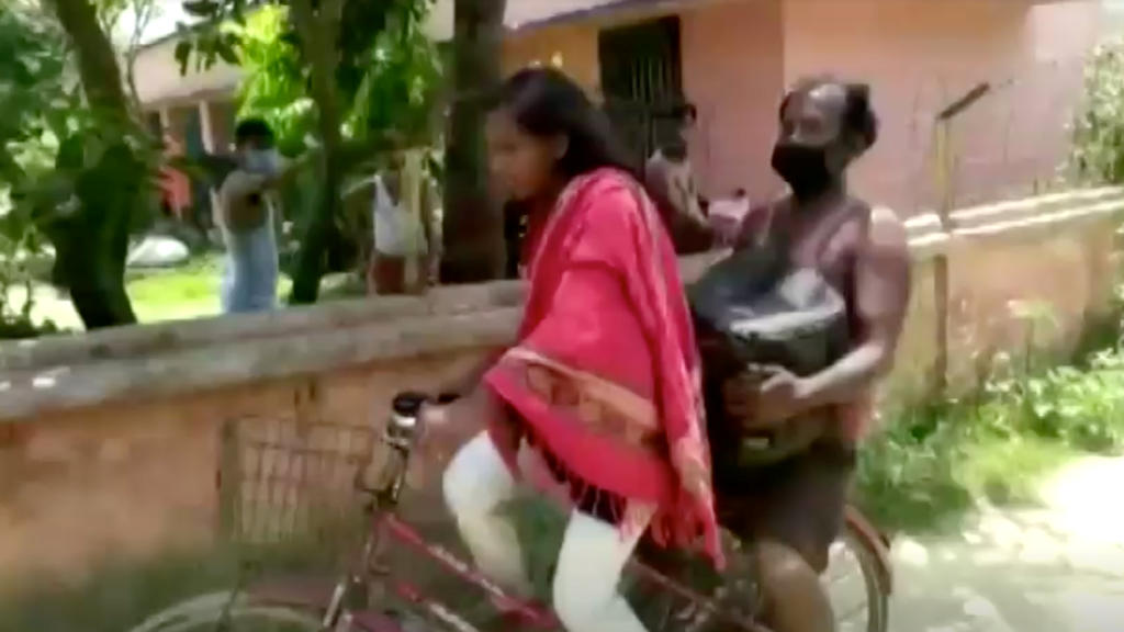 Jyoti Kumari carries her father on the back of her bicycle, in Darbhanga, Bihar, India May 21, 2020 in this still image taken from?video.?ANI via REUTERS TV ATTENTION EDITORS - THIS IMAGE HAS BEEN SUPPLIED BY A THIRD PARTY. INDIA OUT. NO COMMERCIAL O