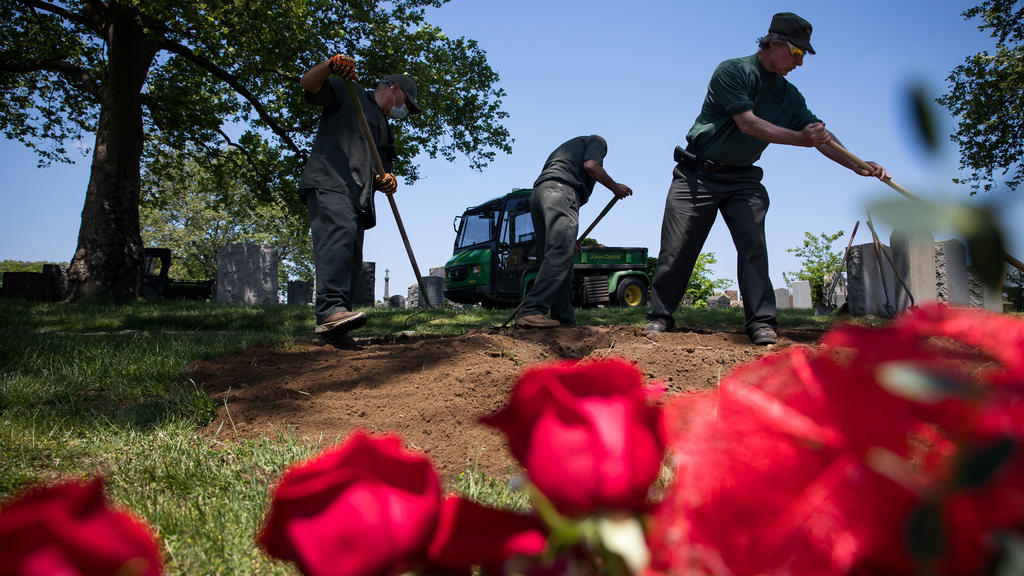 26.05.2020, USA, New York: Mitarbeiter des Friedhofs "Calvary Cemetery" arbeiten während der Corona-Pandemie an einem Grab. Foto: Michael Nagle/XinHua/dpa +++ dpa-Bildfunk +++
