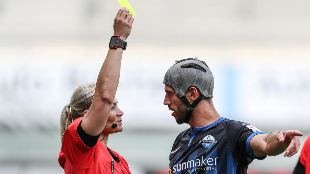 Soccer Football - Bundesliga - SC Paderborn v TSG 1899 Hoffenheim - Benteler Arena, Paderborn, Germany - May 23, 2020 Paderborn's Klaus Gjasula is shown a yellow card by referee Bibiana Steinhaus, as play resumes behind closed doors following the out