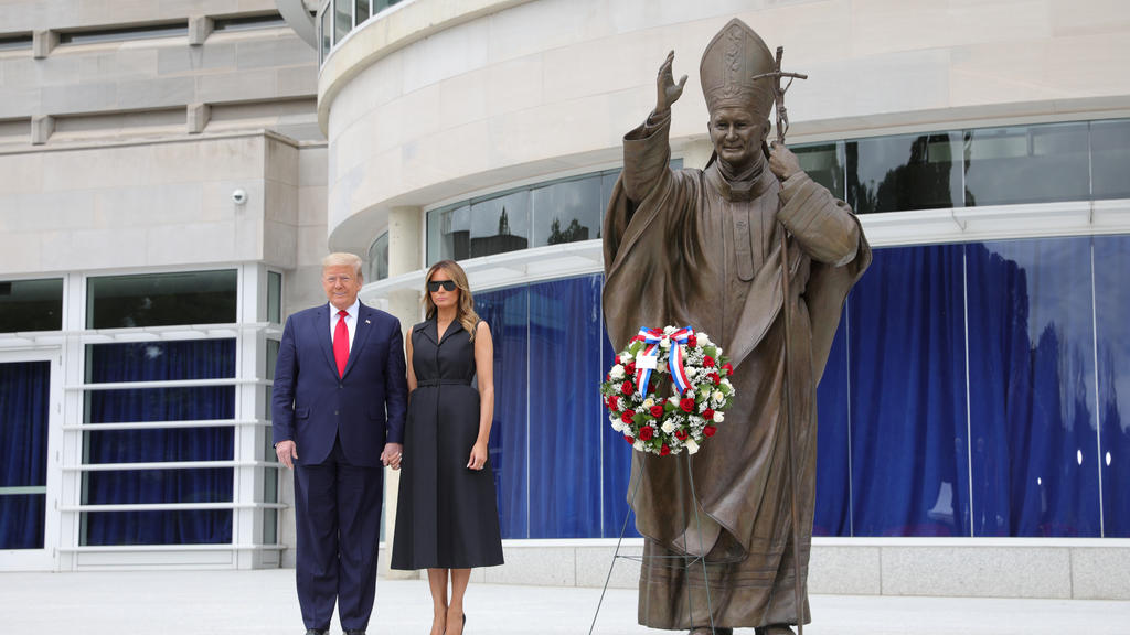 U.S. President Donald Trump and first lady Melania Trump pose beside a statue of Pope John Paul II as they visit the Saint John Paul II National Shrine in Washington, U.S., June 2, 2020. REUTERS/Tom Brenner