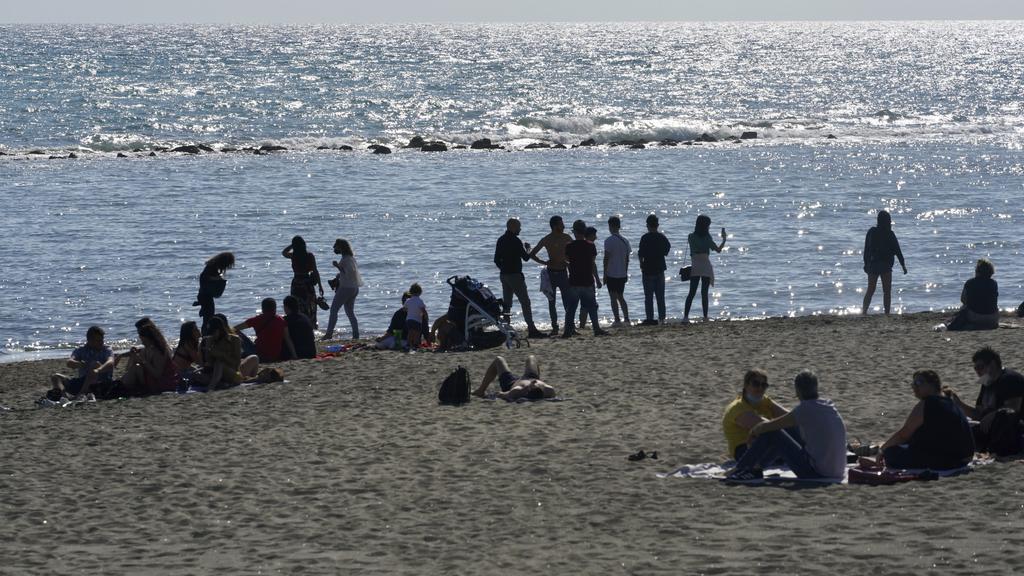 24.05.2020, Italien, Rom: Besucher sitzen und stehen am Strand von Ostia, nachdem zum ersten Mal nach zwei Monaten die Ausgangssperre in Folge der Corona-Pandemie gelockert wurde. In Italien, das am 3. Juni regionale und internationale Grenzen öffnen