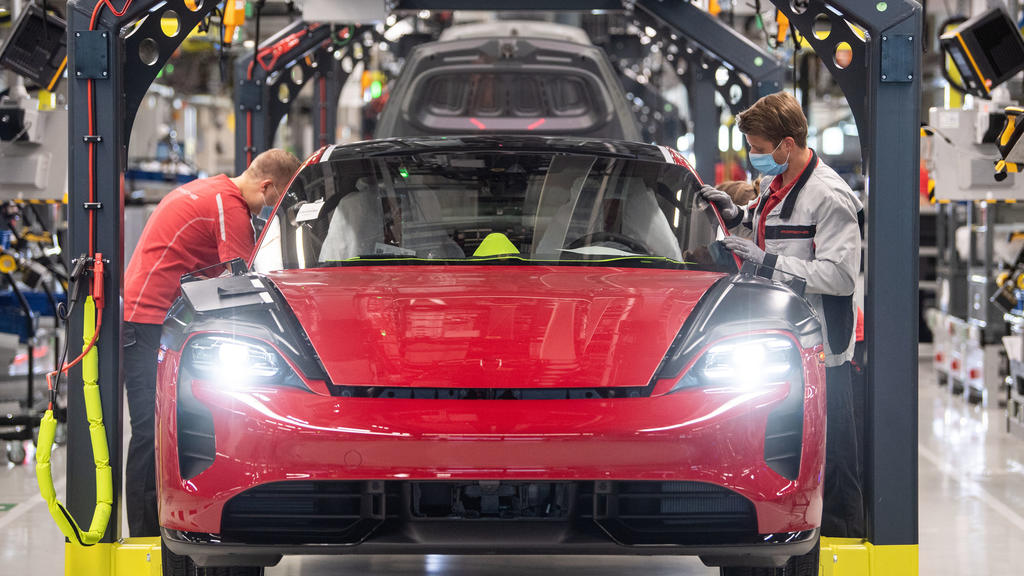 ARCHIV - 12.05.2020, Baden-Württemberg, Stuttgart: Mitarbeiter der Porsche AG tragen in der Produktion des elektrisch angetriebenen Porsches Taycan Masken. Mit einem Milliardenpaket will die Große Koalition die Wirtschaft in der Corona-Krise ankurbel