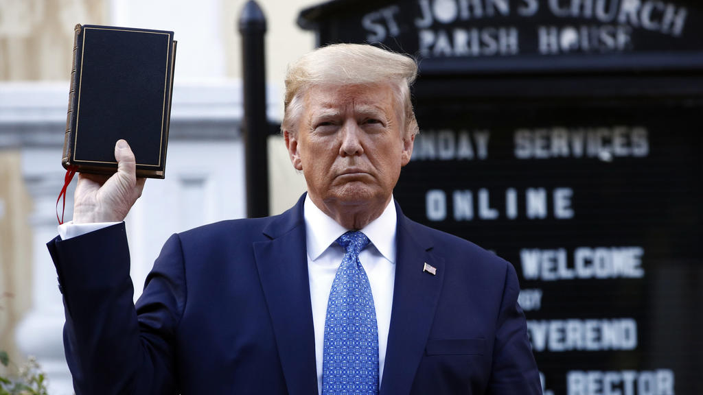 01.06.2020, USA, Washington: Donald Trump, Präsident der USA, hält eine Bibel, während er die St. John's Episcopal Church besucht. Der Park der Kirche wurde während der Proteste in Brand gesteckt. Trump hat die Mobilisierung aller verfügbaren zivilen
