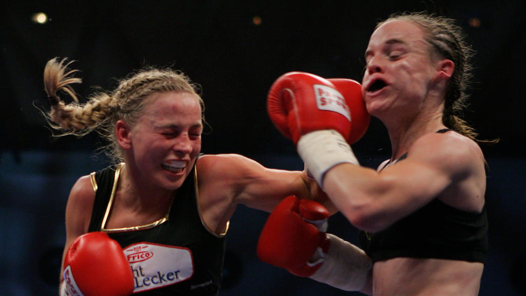 KARLSRUHE, GERMANY - NOVEMBER 30: Regina Halmich of Germany (L) lands a punch against Hagar Shmoulefeld Finer of Israel during their WIBF World Championship flyweight title fight at the DM Arena on November 30, 2007 in Karlsruhe, Germany. Halmich, w