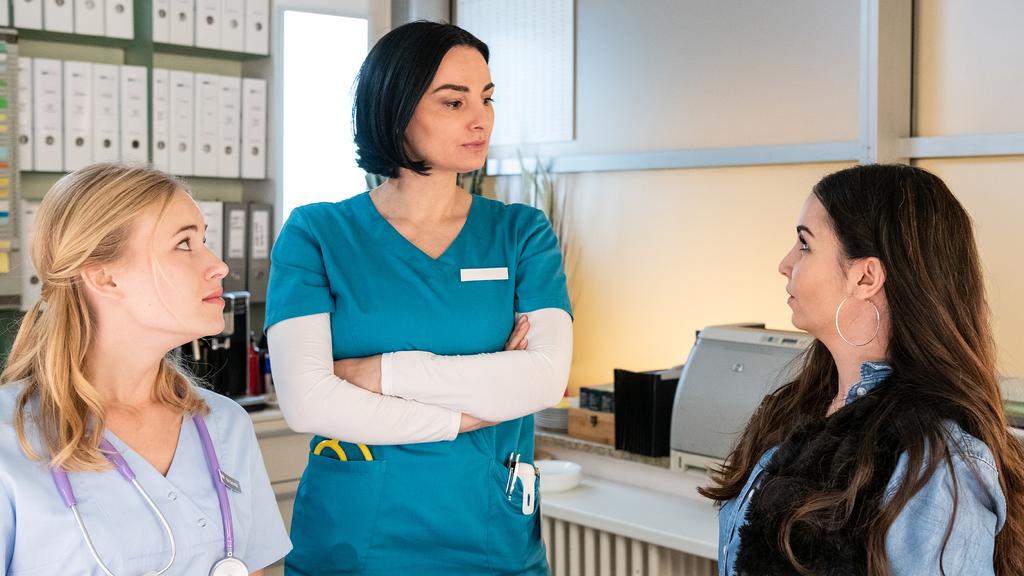 Um das Team zu entlasten, hilft Samira (Sila Sahin-Radlinger, r.) am Empfang der Station aus. Kiki (Valerie Huber, l.) und Nora (Mimi Fiedler, M.) sehen das mit gemischten Gefühlen.Die Verwendung des sendungsbezogenen Materials ist nur mit dem Hinwei
