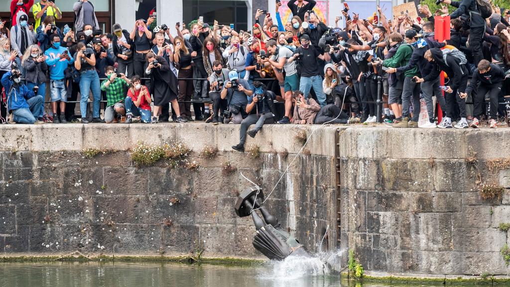 FILE PHOTO: The statue of 17th century slave trader Edward Colston falls into the water after protesters pulled it down and pushed into the docks, during a protest against racial inequality in the aftermath of the death in Minneapolis police custody