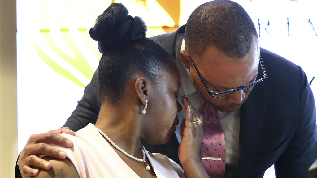 Rayshard Brooks' widow Tomika Miller is comforted by attorney Justin Miller while addressing the media Wednesday, June 17, 2020, in Atlanta, after learning new details of her husband's death. The Fulton County District Attorney Paul Howard had just a