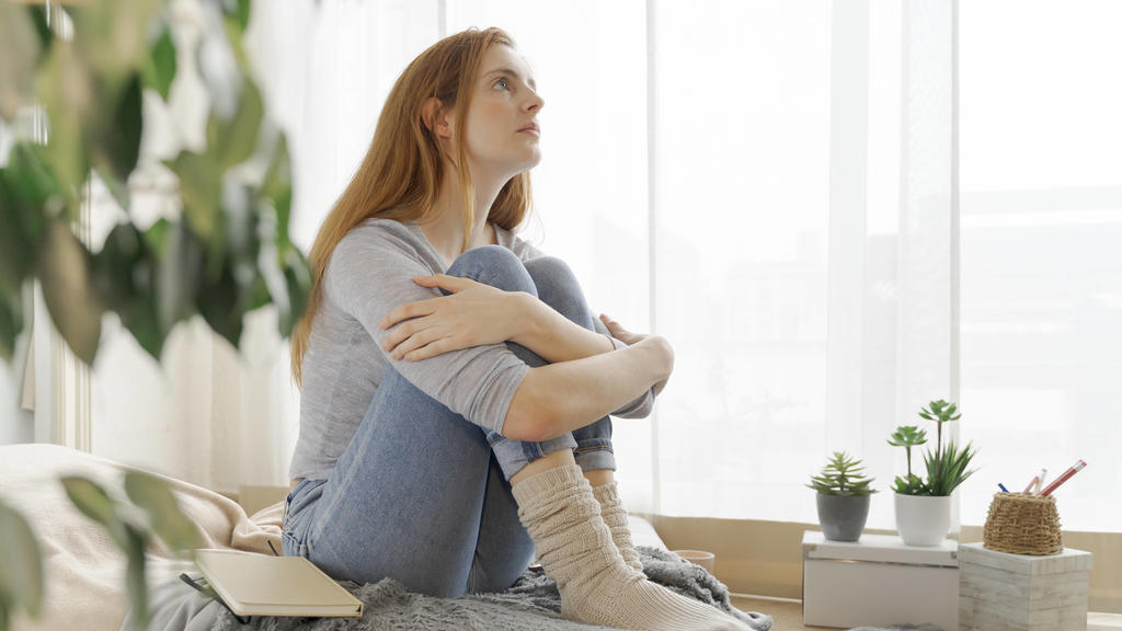Serious young woman at home looking up model released Symbolfoto property released AFVF06014