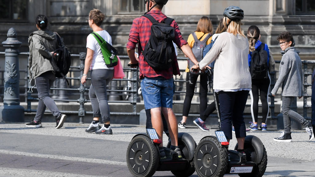 Touristen fahren mit Segways durch Berlin Mitte