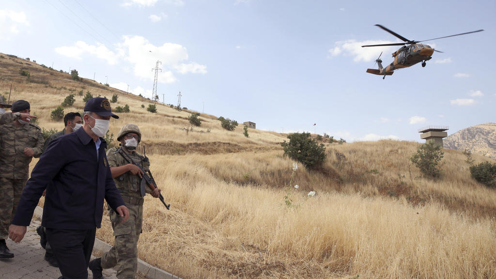 HANDOUT - 19.06.2020, Türkei, ---: Hulusi Akar (2.v.r), Verteidigungsminister der Türkei, besucht mit Mundschutz türkischen Truppen an der Grenze zum Irak in der Provinz Hakkari. Die Operation der türkischen Armee wird fortgesetzt, nachdem am Mittwoc