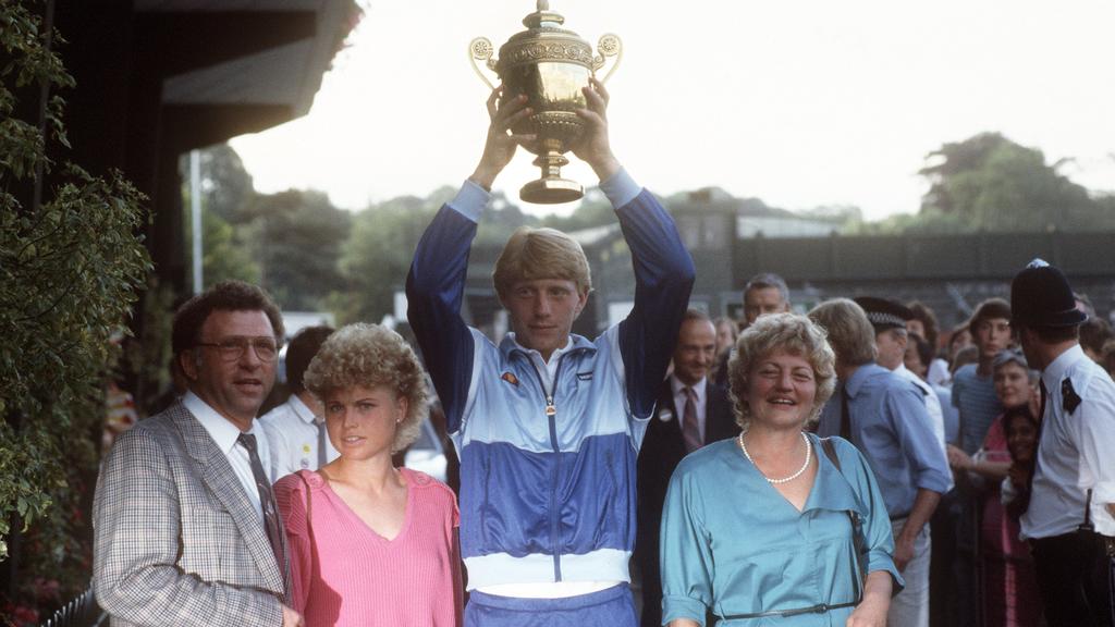 Boris Becker verläßt mit erhobenem Pokal im Kreis seiner Familie nach seinem Sieg den Center-Court in Wimbledon. Rechts seine Mutter Elvira, links Vater Karl-Heinz und Schwester Sabine. Der 17-jährige, ungesetzte Tennisspieler aus Leimen gewann als j