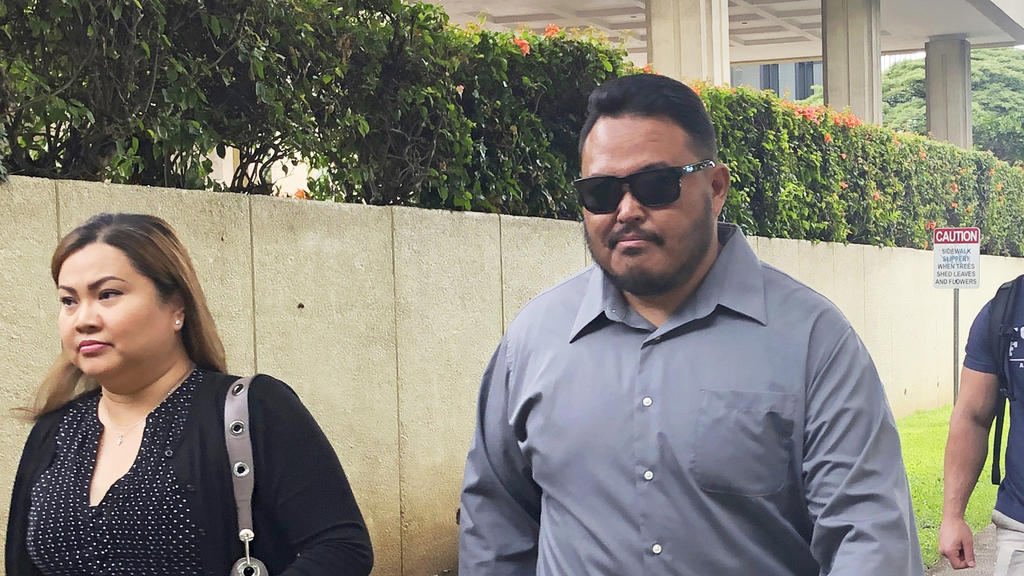 FILE - In this Sept. 25, 2019 file photo, former Honolulu police officer Reginald Ramones, center, walks down a street in Honolulu. Samuel Ingall, a homeless man, is suing the Honolulu Police Department and the city after he says officers forced him