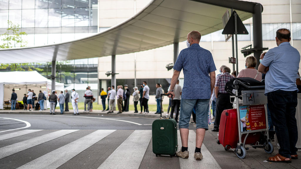 25.07.2020, Nordrhein-Westfalen, Köln: Reisende stehen am Corona-Testzentrum am Flughafen Köln/Bonn an. An den Flughäfen in Düsseldorf, Köln/Bonn und Dortmund haben kostenlose Corona-Tests für Rückkehrer aus Risikogebieten begonnen. Foto: Marius Beck