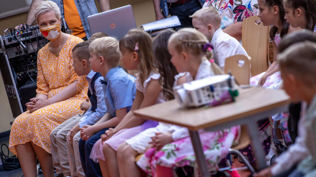 01.08.2020, Mecklenburg-Vorpommern, Schwerin: Manuela Schwesig (l, SPD), die Ministerpräsidentin von Mecklenburg-Vorpommern, sitzt bei der Einschulungsfeier in der Grundschule Lankow mit den ABC-Schützen in der ersten Reihe der Feierstunde. In Meckle