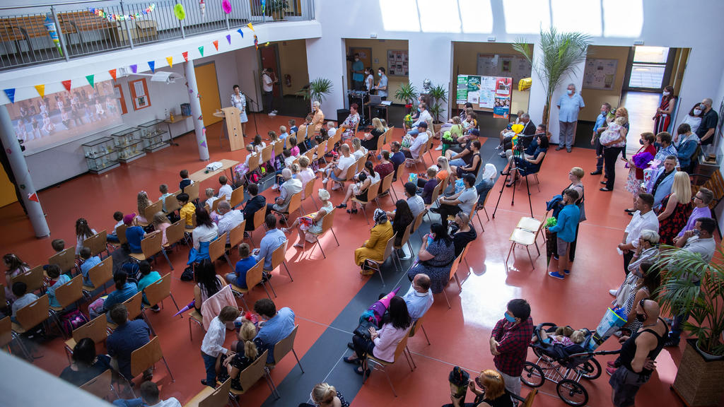 01.08.2020, Mecklenburg-Vorpommern, Schwerin: ABC-Schützen und ihre Eltern sitzen bei der Einschulungsfeier in der Grundschule Lankow mit den vorgegebenen Mindesabständen. In Mecklenburg-Vorpommerns Grundschulen werden unter Beachtung der Corona-Schu