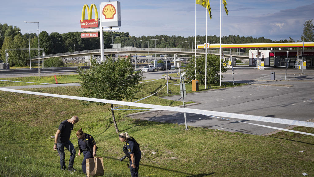 02.08.2020, Schweden, Norsborg: Polizisten ermitteln an einem Tatort nahe einer Tankstelle an der ein Mädchen in der Nacht zu Sonntag (2. August) angeschossen wurde. Ein Mädchen im Teenageralter ist in der Nacht zum Sonntag (2. August) in der Nähe ei