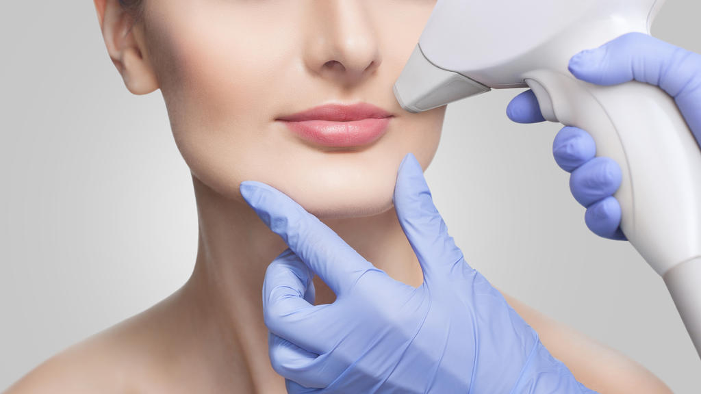 Junge Frau lässt sich mit IPL Laser Gesichtshaare entfernen