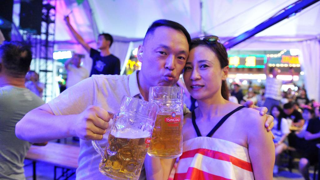 Chinese tourists pose for photos as they enjoy beer during the 28th Qingdao International Beer Festival in Qingdao city, east China's Shandong province, 31 July 2018. The 28th Qingdao International Beer Festival, one of the largest beer festivals in