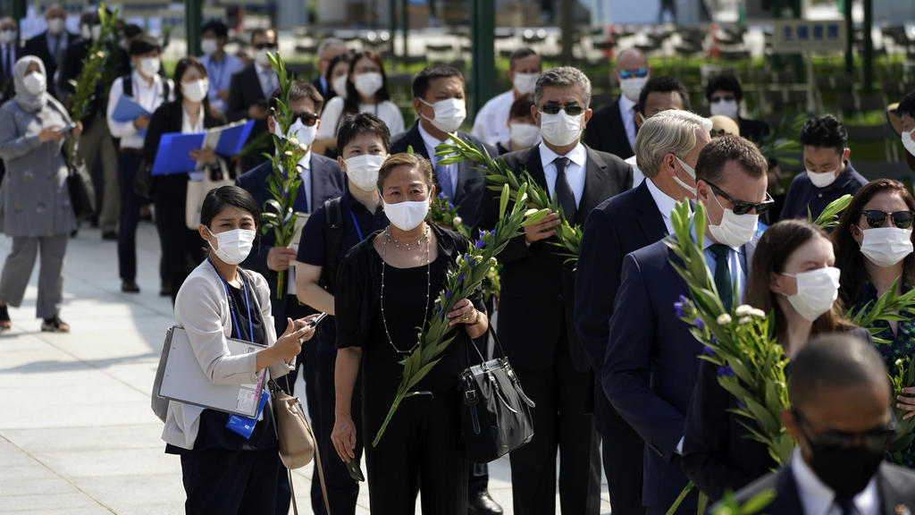 05.08.2020, Japan, Hiroshima: Diplomaten stehen vor dem Jahrestag des Atombombenabwurfs über Hiroshima Schlange, um am Kenotaph für die Atombombenopfer in der Nähe des Hiroshima Peace Memorial Museums Blumen abzulegen. Am 6. August 2020 um 8.15 Uhr (