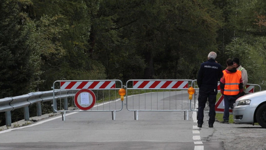 06.08.2020, Italien, Courmayeur: Polizisten stehen an einer Straßensperre. Der Planpincieux-Gletscher unterhalb des Mont Blanc bedrohte gut ein Dutzend Einheimische und rund 50 Touristen. Diese wurden daher von Carabinieri und anderen Einsatzkräften