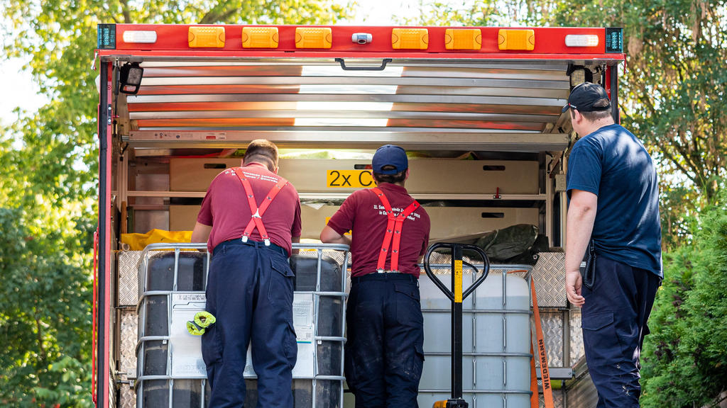 08.08.2020, Niedersachsen, Lauenau: Einsatzkräfte der Freiwilligen Feuerwehr Lauenau entladen Wasserbehälter von einem LKW. In der Gemeinde im Landkreis Schaumburg ist die Wasserversorgung nach warmen Tagen und während der Corona-Pandemie zusammengeb