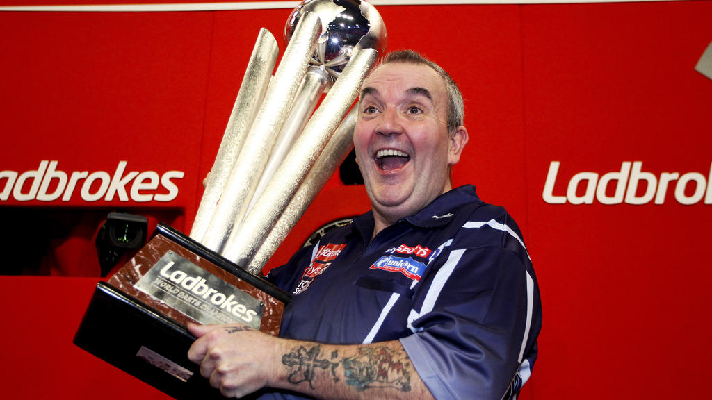 LONDON, ENGLAND - JANUARY 1: Phil Taylor of England celebrates with the trophy after winning the final of the 2013 Ladbrokes.com World Darts Championship at the Alexandra Palace on January 1, 2013 in London, England. (Photo by Ben Hoskins/Getty Image