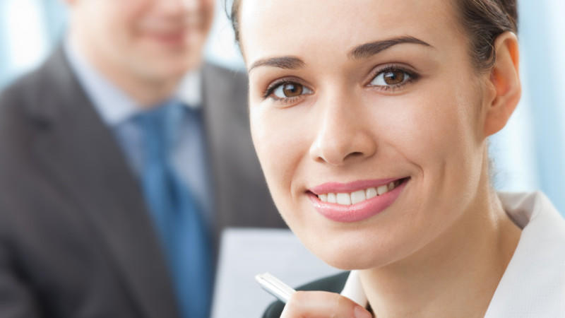Portrait of successful businesswoman and colleague on background, at office