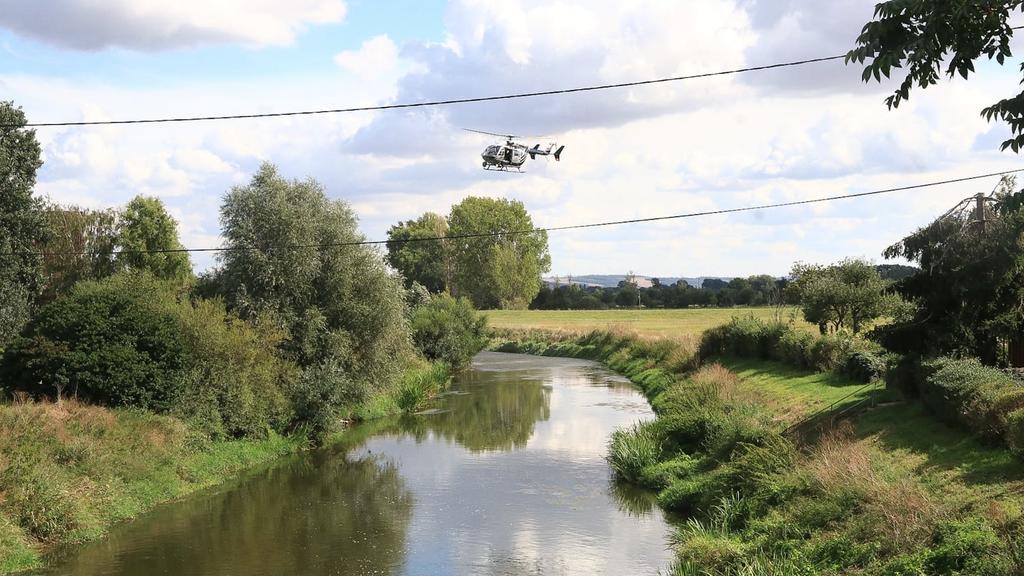 06.09.2020, Thüringen, -: Ein Helikopter überfliegt die Unstrut. Feuerwehrleute suchen seit Sonntagmittag, 06.09.2020 am Flussufer der Unstrut bei Schönewerda (Kyffhäuserkreis) nach einem Krokodil, das eine Pferdebesitzerin gesichtet haben will. Der