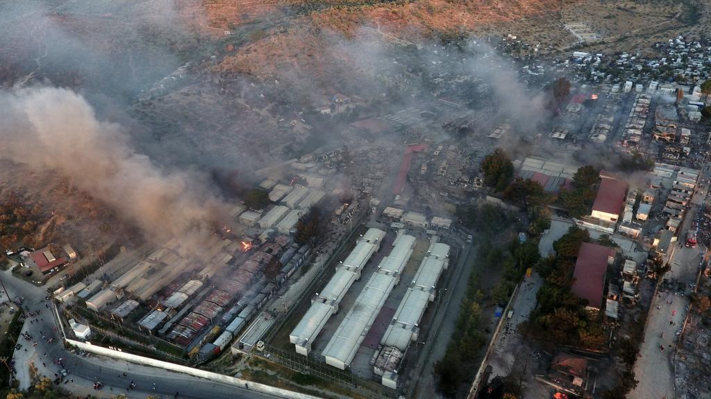 09.09.2020, Griechenland, Lesbos: Rauch steigt aus Container-Häuser und Zelten im Flüchtlingslager Moria auf der nordöstlichen Ägäisinsel Lesbos (Luftaufnahme mit einer Drohne). Ein Feuer fegte durch Griechenlands größtes Flüchtlingslager, das wegen