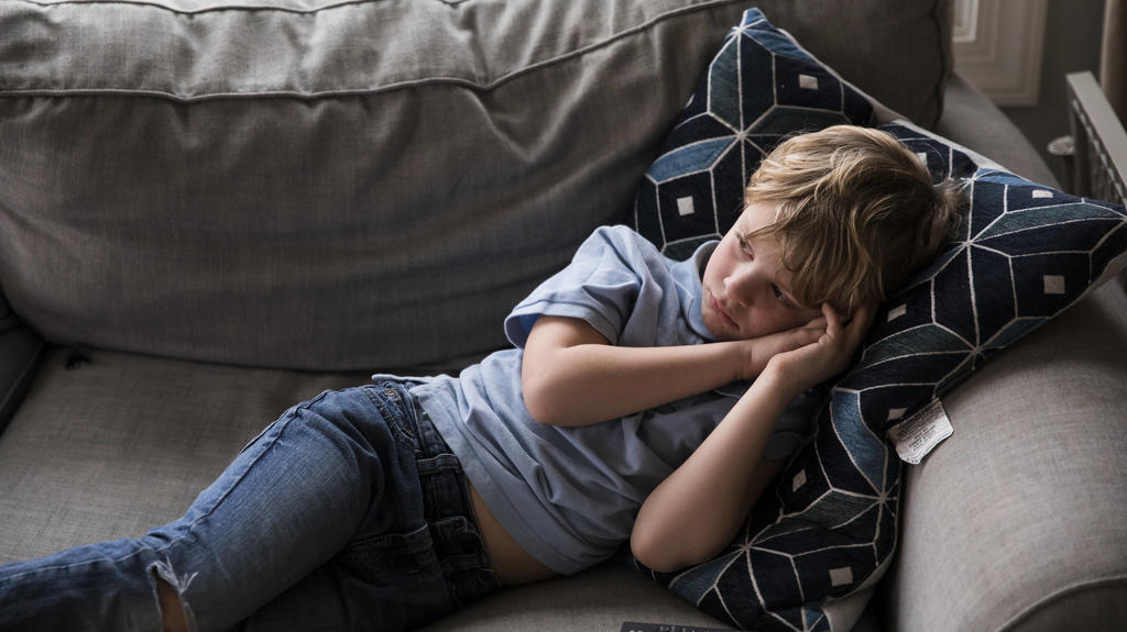 Sad Blonde Boy Watches TV While Laying on Couch Easton, MD, United States PUBLICATIONxINxGERxSUIxAUTxONLY CREMJA200506A-357519-01,model released, Symbolfoto