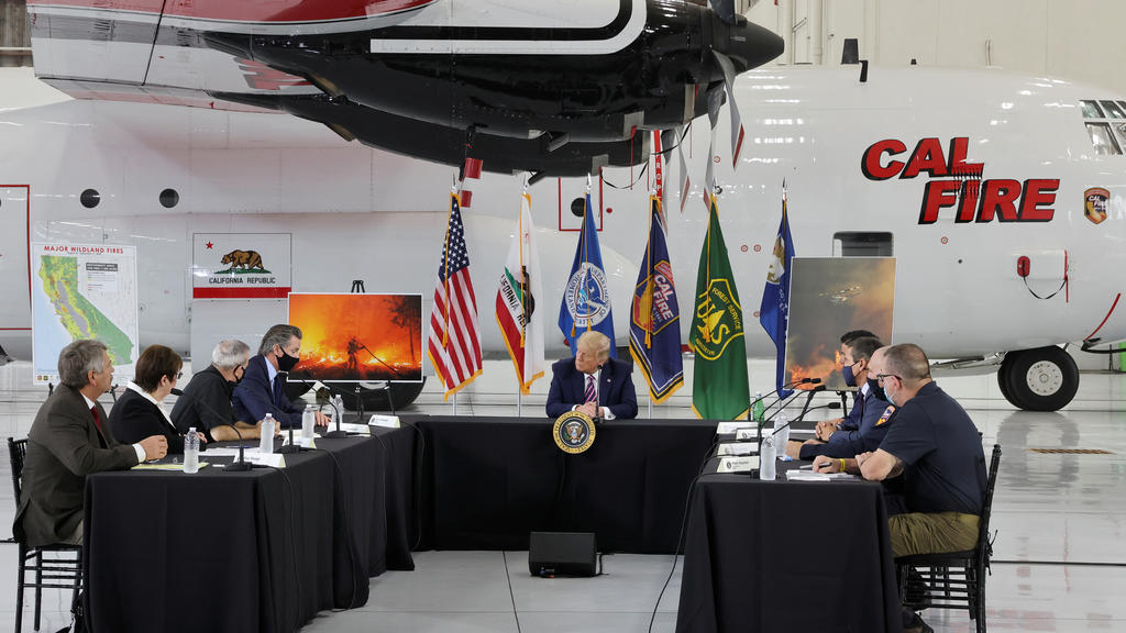 U.S. President Donald Trump sits in front of a CAL FIRE firefighting aircraft as California Governor Gavin Newsom speaks during a briefing on wildfires in McClellan Park, California, U.S., September 14, 2020. REUTERS/Jonathan Ernst
