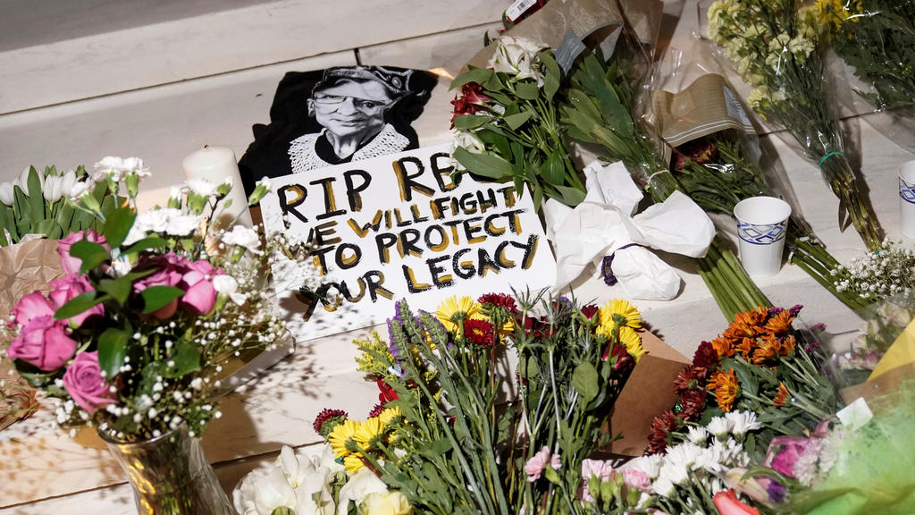 Candles and flowers are lit next an illustration of Associate Justice Ruth Bader Ginsburg as people mourn her death at the Supreme Court in Washington, U.S., September 19, 2020. REUTERS/Joshua Roberts