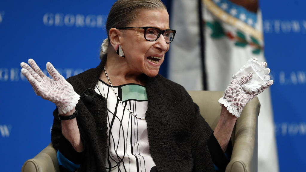 FILE - In this Sept. 20, 2017 file photo, U.S. Supreme Court Justice Ruth Bader Ginsburg reacts to applause as she is introduced by William Treanor, Dean and Executive Vice President of Georgetown University Law Center, at the Georgetown University L