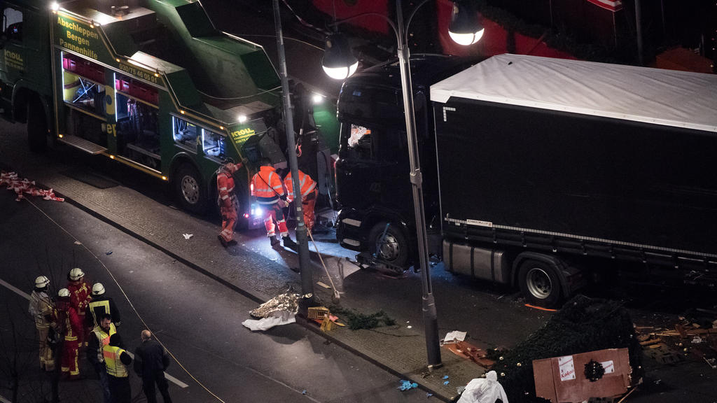 Arbeiter befestigen am 20.12.2016 auf dem Weihnachtsmarkt am Breitscheidplatz in Berlin den Sattelschlepper an einem Abschleppwagen. Bei dem möglichen Anschlag mit einem Lastwagen auf den Weihnachtsmarkt an der Gedächtniskirche am Montagabend (19.12.