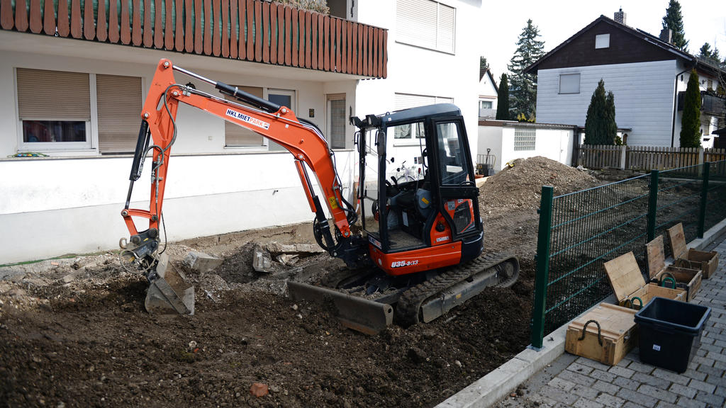 Ein Bagger steht vor einem Haus im Stadtteil Freimann in München, in dessen Garten große Mengen an Sprengstoff gefunden wurden.