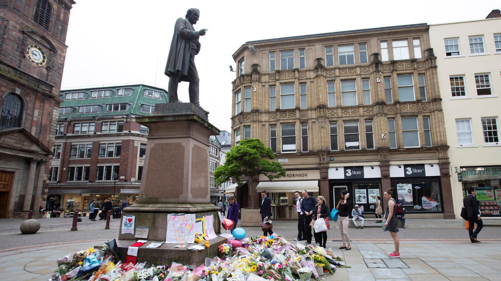 People stop to look at flowers and messsages on an impromptu memorial in St Anns Square for the victims of an attack at Manchester Arena, Manchester, Britain, May 24, 2017. REUTERS/Jon Super