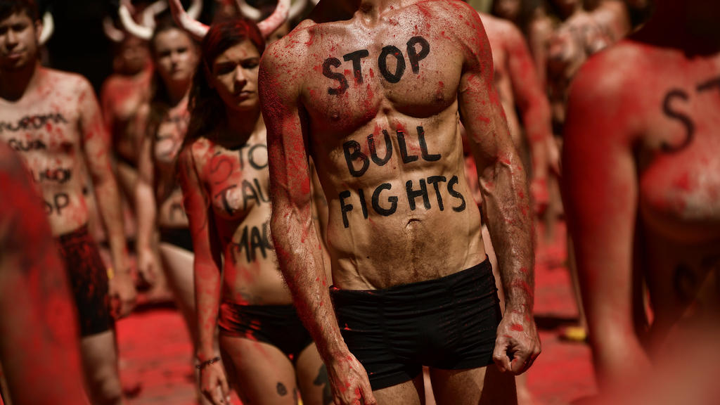 Menschen mit aufgesetzten Stier-Hörnern demonstrieren am 05.07.2017 in Pamplona (Spanien) gegen das Stierkampf-Festival «San Fermin». Foto: Alvaro Barrientos/AP/dpa +++(c) dpa - Bildfunk+++