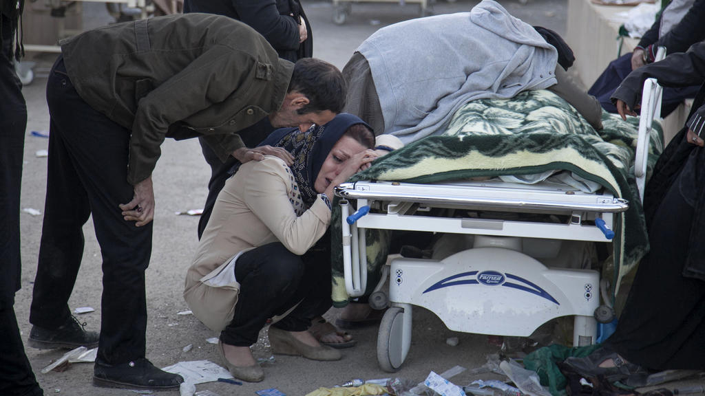 HANDOUT - Dieses von der Tasnim News Agency zur Verfügung gestellte Foto zeigt am 13.11.2017 in Sarpol-E-Zahab (Iran) Familienangehörige, die vor der Leiche eines Opfers des Erdbebens trauern. Nach dem schweren Erdbeben in den südlichen Kurdengebiete