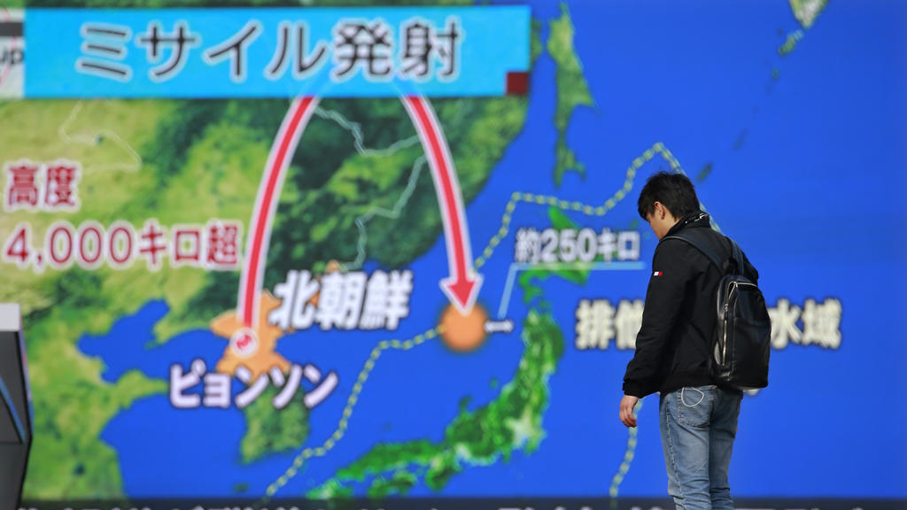 Ein Mann steht am 29.11.2017 in Tokio, Japan, vor einem riesigen Bildschirm, der eine Nachrichtensendung zu einem Raketenstart Nordkoreas zeigt. Nordkorea hat seine bisher weitreichendste Interkontinentalrakete getestet, die möglicherweise bis in die