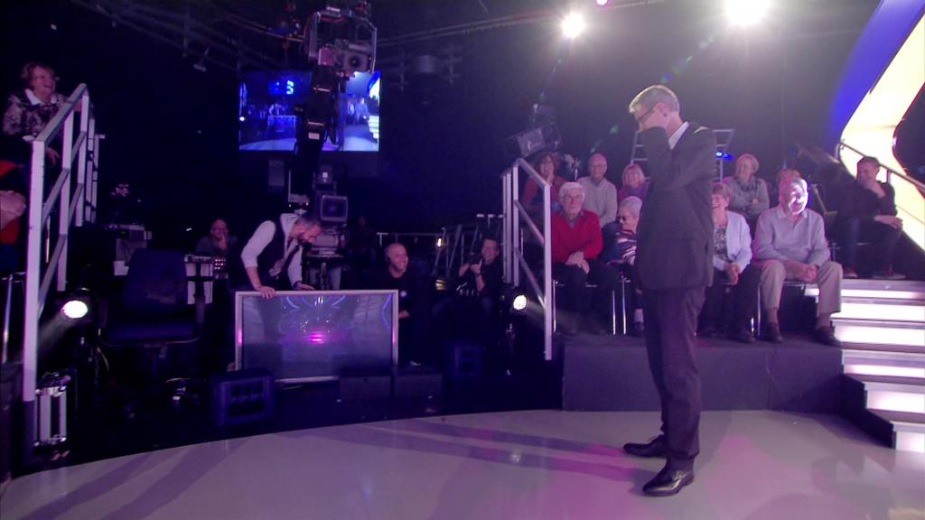 Ein Fernseher ist während der Sendung umgekippt. Günther Jauch schaut sich das aus der Nähe an.