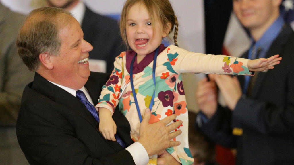 Democratic Alabama U.S. Senate candidate Doug Jones holds his granddaughter as he celebrates with supporters at the election night party in Birmingham, Alabama, U.S., December 12, 2017. REUTERS/Marvin Gentry