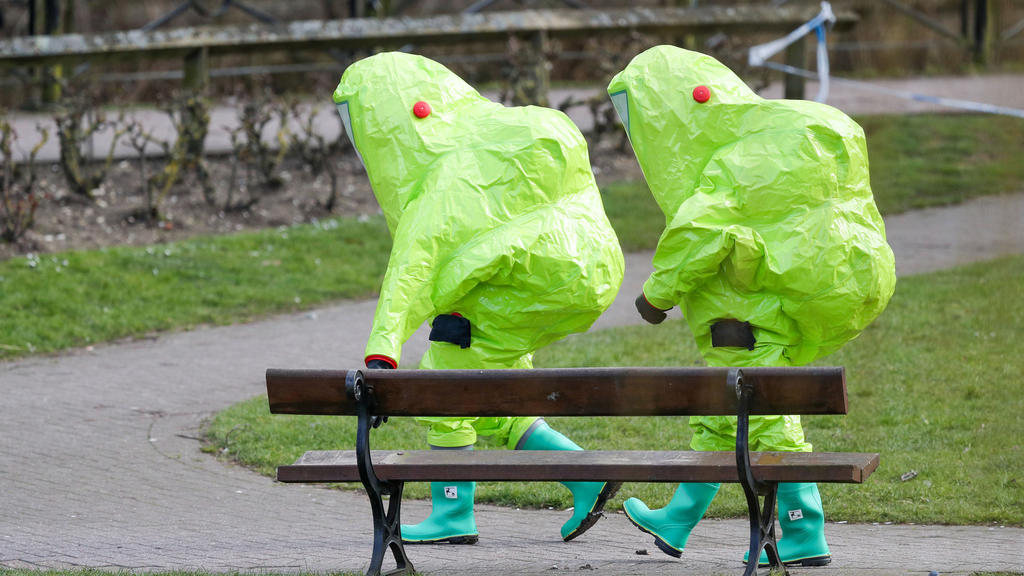 dpatopbilder - 08.03.2018, Großbritannien, Salisbury: Einsatzkräfte in Schutzanzügen ziehen sich zurück, nachdem sie über der Bank, auf der der frühere Doppelagent Sergei Skripal und seine Tochter mit Vergiftungserscheinungen aufgefunden wurden, ein