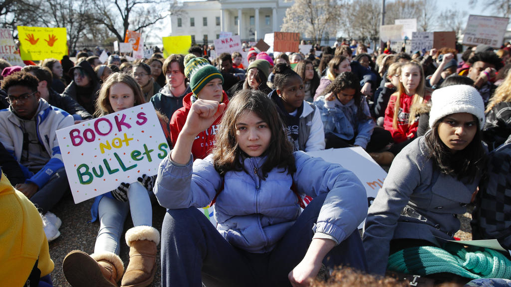 14.03.2018, USA, Washington:Schüler sitzen während einer Demonstration gegen Waffengewalt schweigend vor dem Weißen Haus. In zahlreichen Schulen im ganzen Land stand ab 10.00 Uhr Ostküstenzeit (15.00 Uhr MEZ) der Unterricht für 17 Minuten lang still.